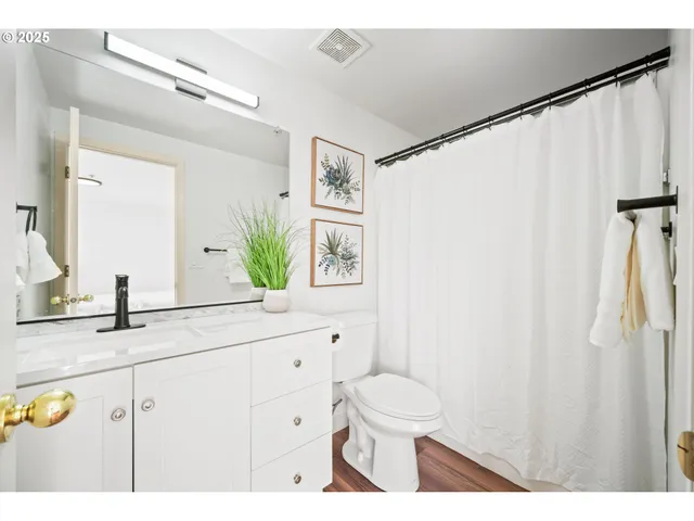 a bathroom with a granite countertop sink a toilet and a mirror