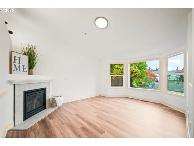 a view of empty room with floor to ceiling window and fireplace
