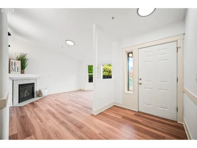 a view of empty room with wooden floor and fireplace