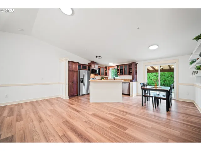 a room with stainless steel appliances wooden floors and view living room