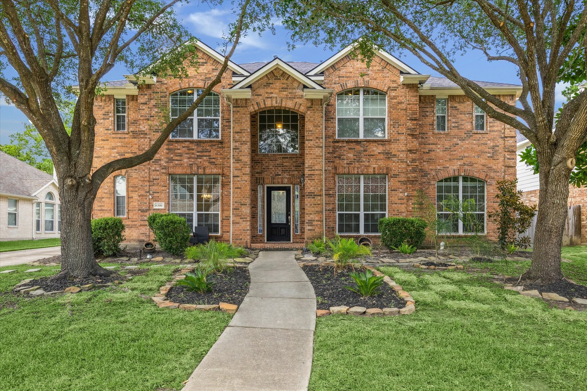 a front view of a house with yard and green space