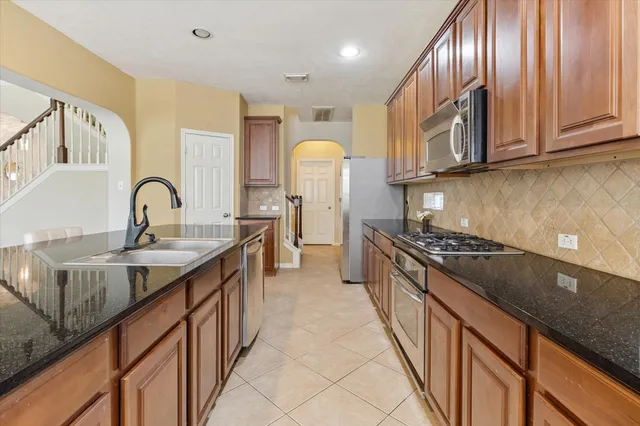 a kitchen with stainless steel appliances granite countertop a sink stove and cabinets
