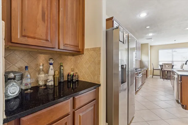 a kitchen with stainless steel appliances granite countertop a refrigerator and a sink