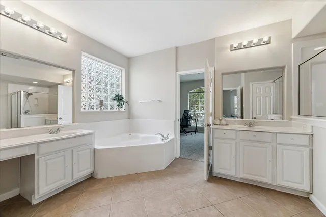 a bathroom with a tub a sink and mirror