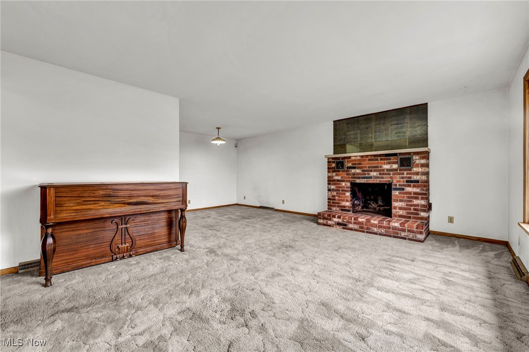 1140 Keefer Road Girard, OH 44420 - Photo 5 of 49 Unfurnished living room with carpet floors and a brick fireplace