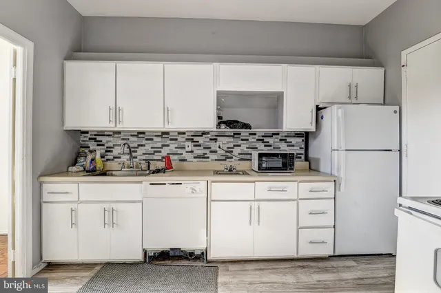 a kitchen with white cabinets and refrigerator