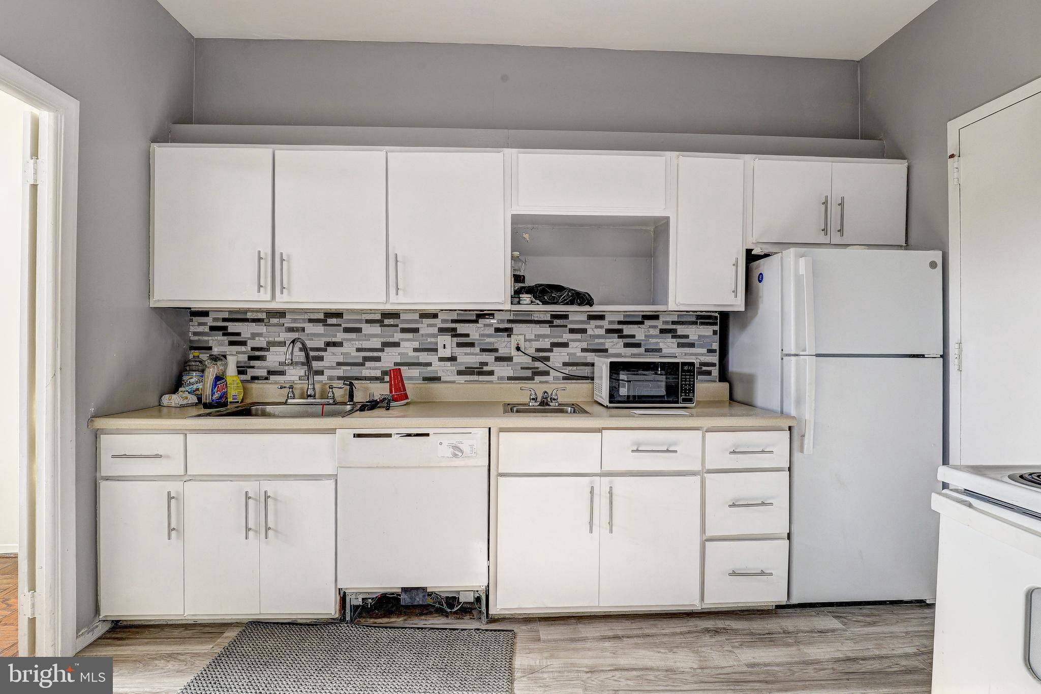 6606 Park Heights Avenue, Unit 111 Baltimore, MD 21215 - Photo 3 of 32 a kitchen with white cabinets and refrigerator