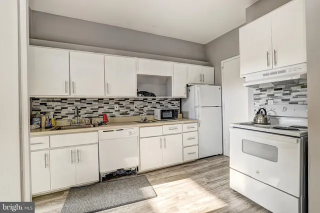 a kitchen with white cabinets and white appliances