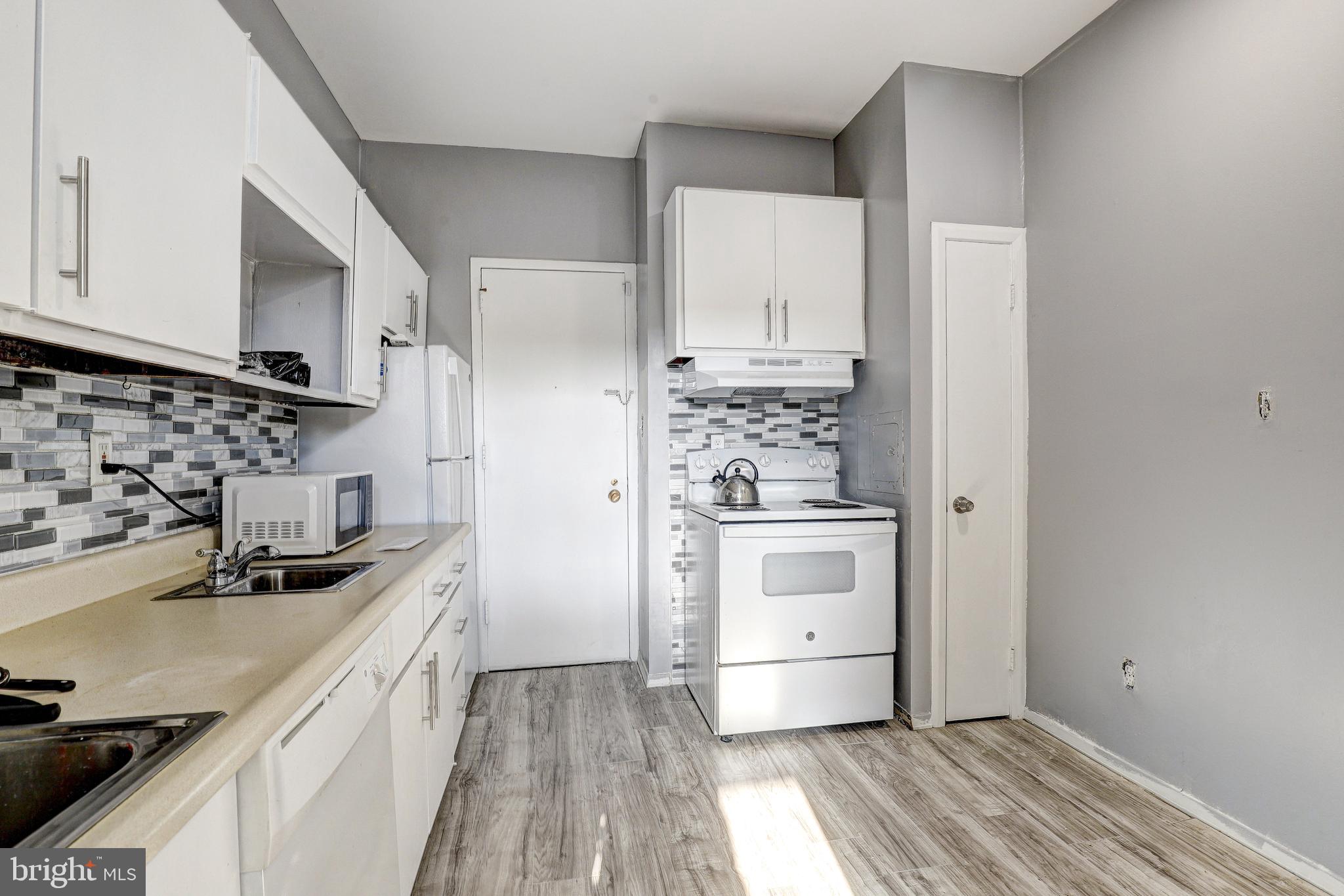 6606 Park Heights Avenue, Unit 111 Baltimore, MD 21215 - Photo 6 of 32 a kitchen with stainless steel appliances a sink stove and refrigerator