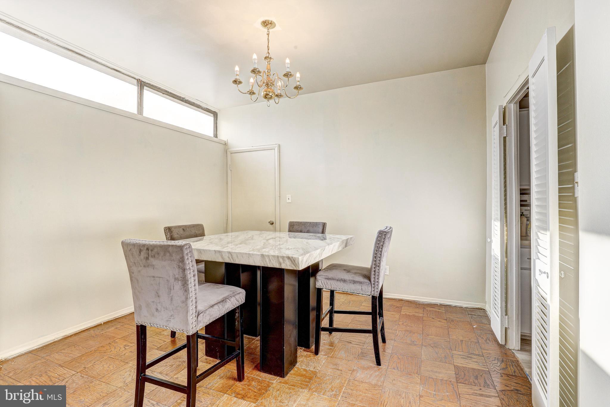 6606 Park Heights Avenue, Unit 111 Baltimore, MD 21215 - Photo 8 of 32 a view of a dining room with furniture and chandelier
