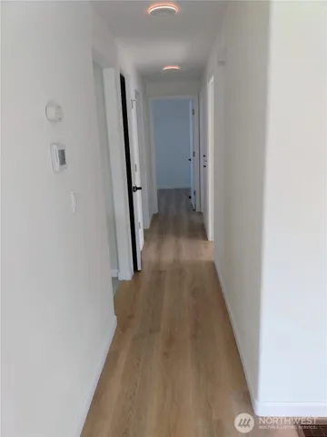 a view of a hallway with wooden floor