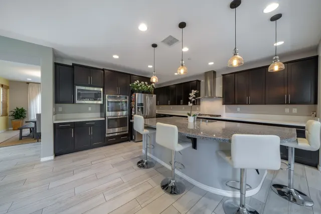 a kitchen with stainless steel appliances granite countertop a sink counter space and wooden floor