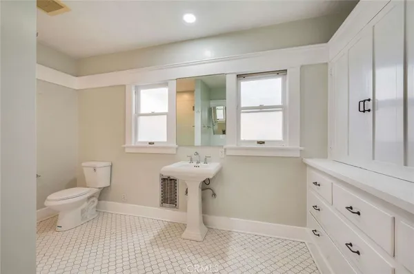 a bathroom with a sink a toilet and a window