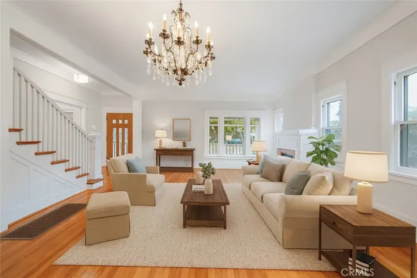 a living room with furniture or chandelier and a wooden floor
