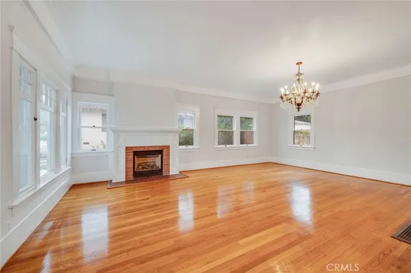 a view of a livingroom with a fireplace window and wooden floor