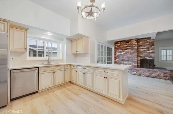 a kitchen with granite countertop stainless steel appliances a stove a sink and cabinets