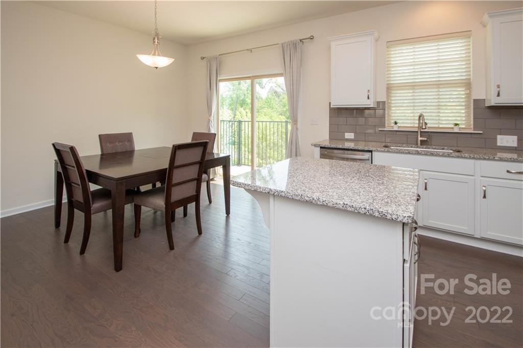 820 Ruckers Court Tega Cay, SC 29708 - Photo 14 of 46 a kitchen with stainless steel appliances granite countertop a sink a stove a dining table and chairs