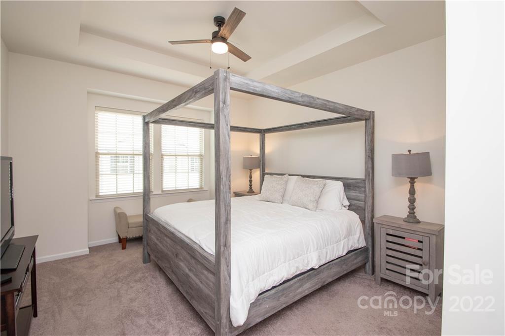 820 Ruckers Court Tega Cay, SC 29708 - Photo 26 of 46 a large bed sitting in a bedroom next to a window and a chandelier