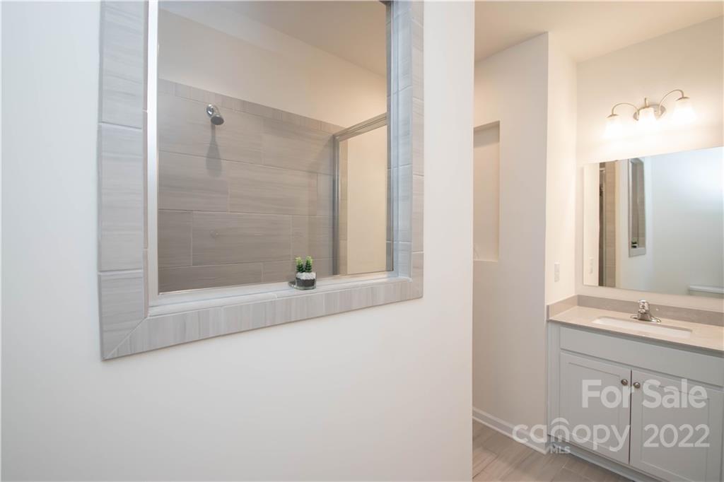 820 Ruckers Court Tega Cay, SC 29708 - Photo 29 of 46 a bathroom with a granite countertop bathtub shower sink and mirror