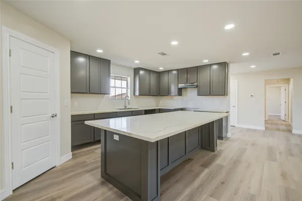 a kitchen with kitchen island a sink dishwasher stove and wooden cabinets