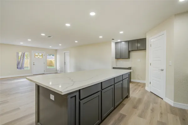 a kitchen with a sink a refrigerator and wooden floor