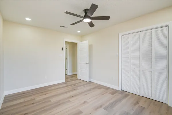 wooden floor in an empty room with a ceiling fan