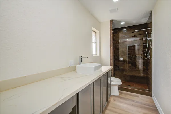 a bathroom with a sink a toilet and shower