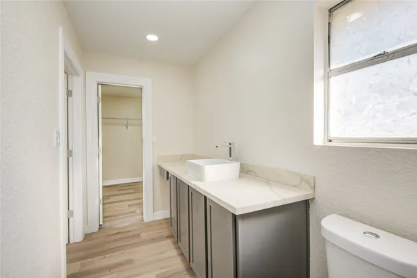 a bathroom with a sink vanity and a toilet