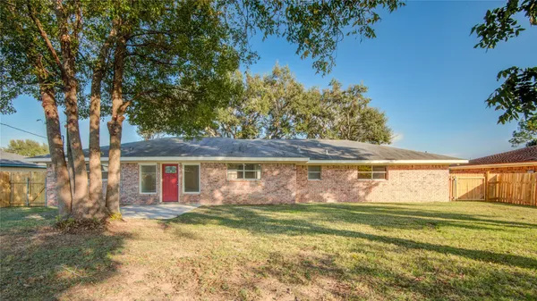 a view of a house with a yard and a tree