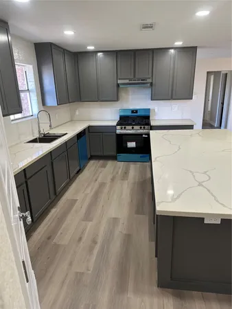 a kitchen with stainless steel appliances kitchen island a sink stove and cabinets