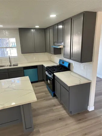 a kitchen with stainless steel appliances a sink a stove a refrigerator and cabinets