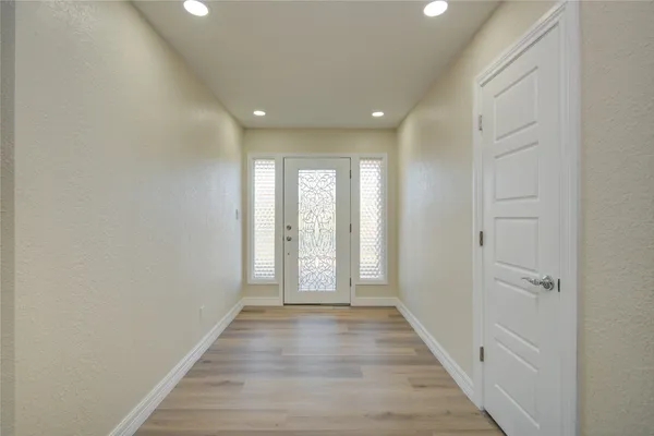 a view of a hallway with wooden floor and closet in a room