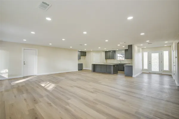 a view of an empty room and kitchen view