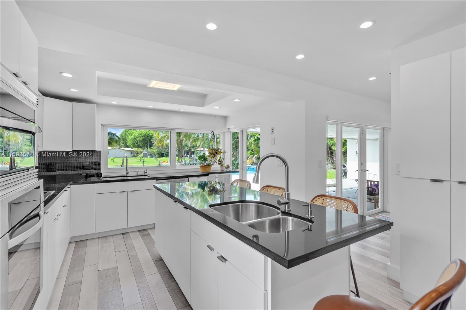 6341 Lake June Road Miami Lakes, FL 33014 - Photo 13 of 55 a kitchen with kitchen island granite countertop a sink a counter space appliances and windows