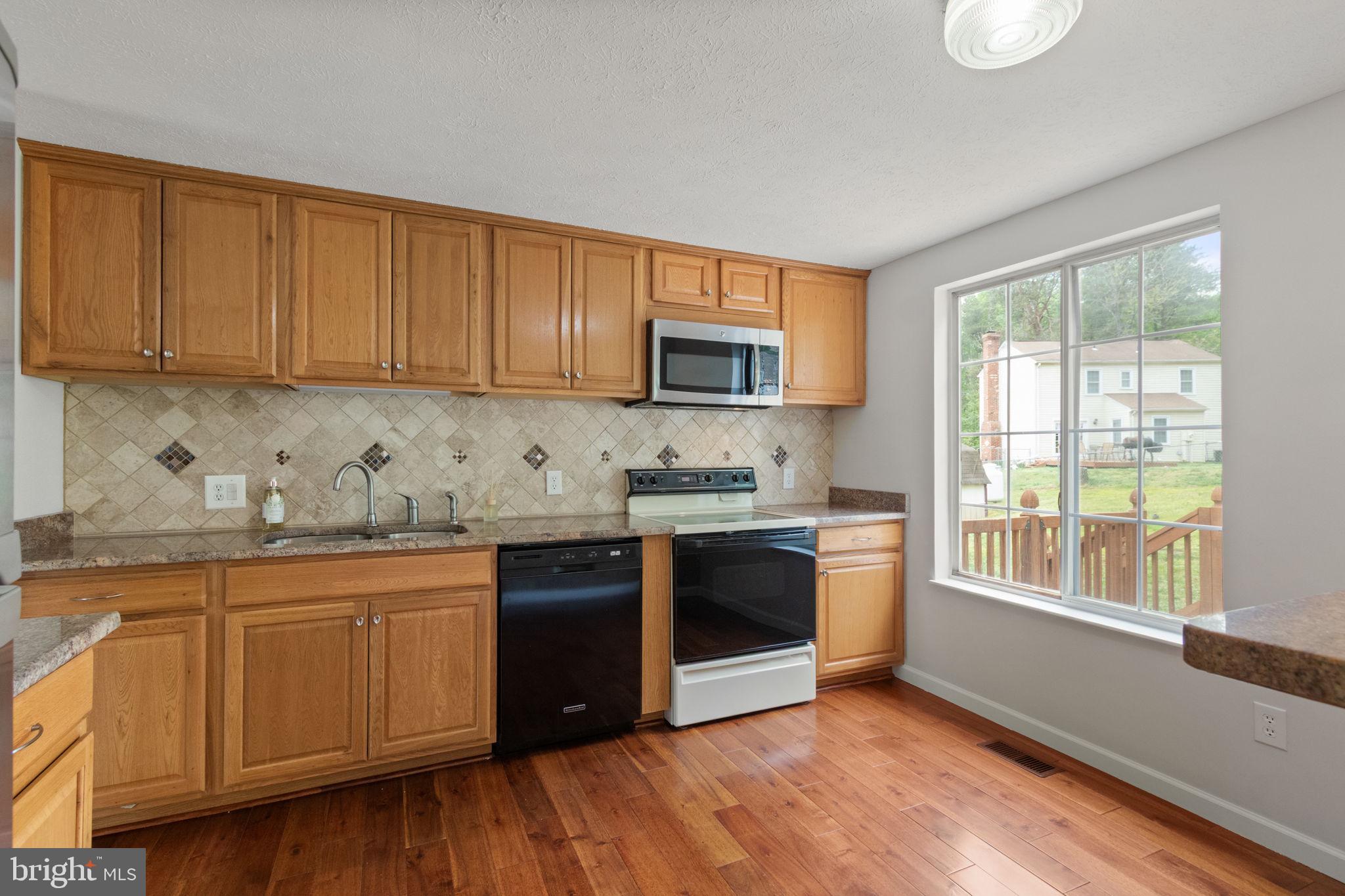 3 Cherry Laurel Drive Fredericksburg, VA 22405 - Photo 12 of 42 a kitchen with stainless steel appliances granite countertop a stove a sink dishwasher and a microwave oven with cabinets