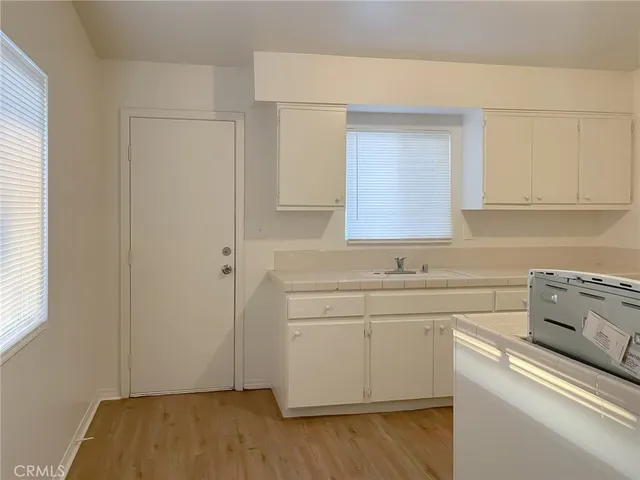 a view of cabinets a sink and wooden floor