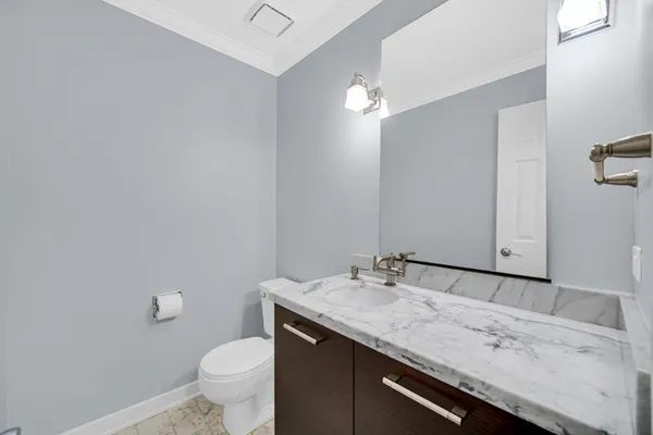a bathroom with a granite countertop sink a toilet and a mirror