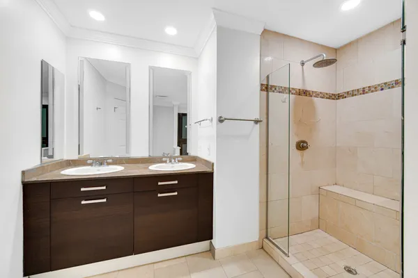 a bathroom with a granite countertop sink a mirror a shower and vanity