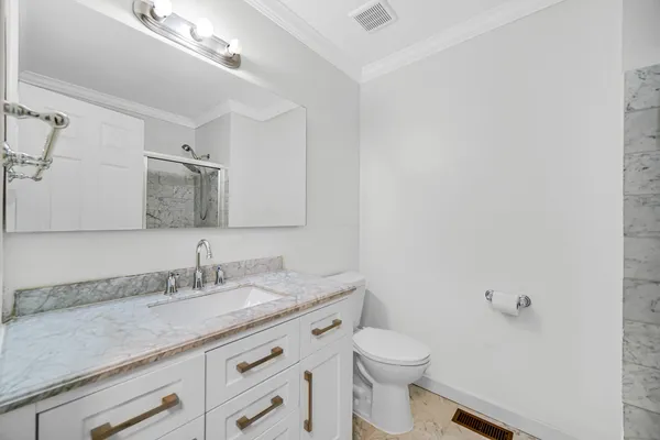 a bathroom with a granite countertop sink a toilet and a mirror