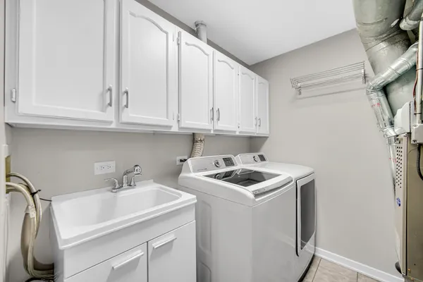 a kitchen with stainless steel appliances granite countertop a sink a stove and a refrigerator with wooden cabinets