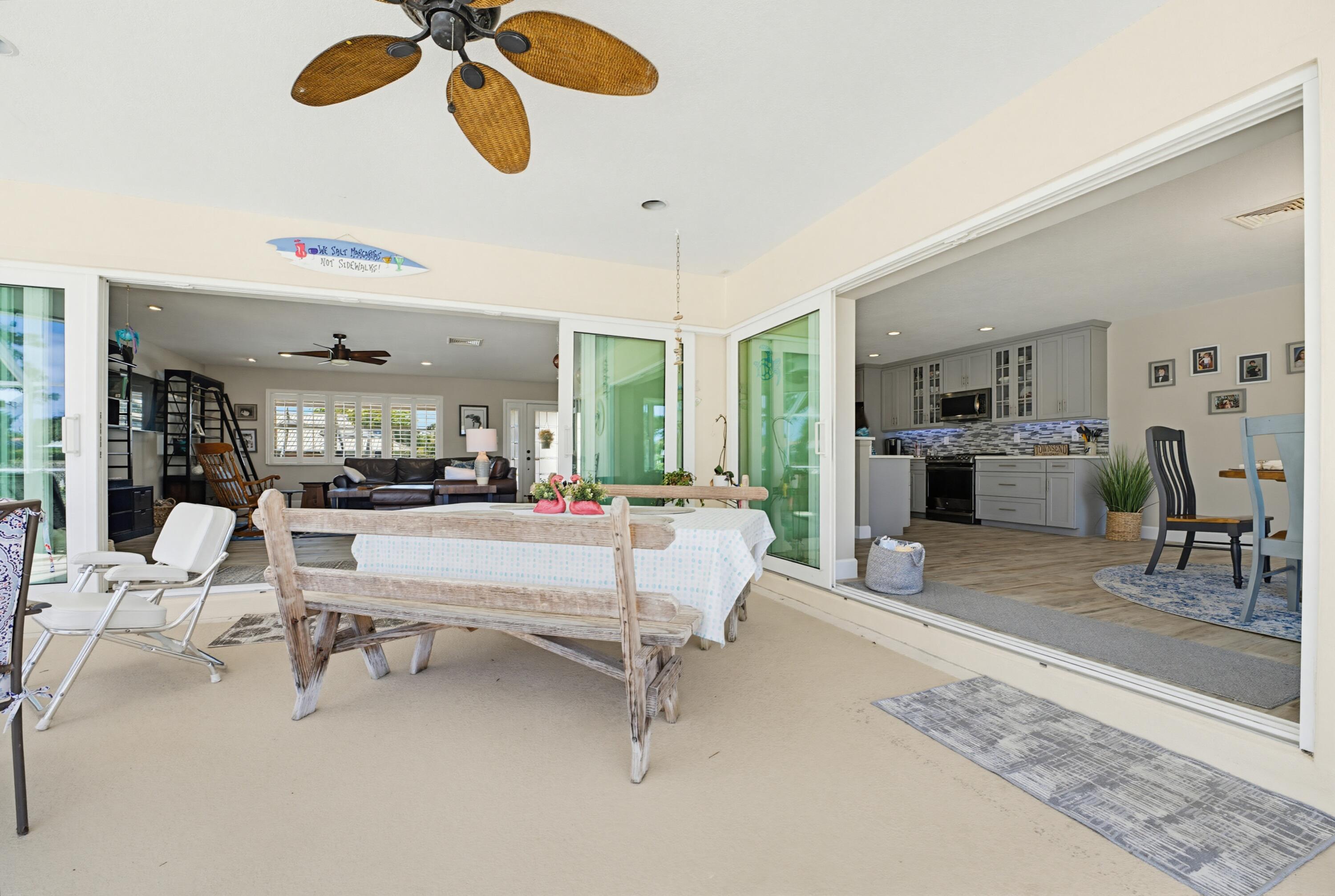 3491 Southeast Clubhouse Place Stuart, FL 34997 - Photo 13 of 43 a living room with couches and dining table with wooden floor