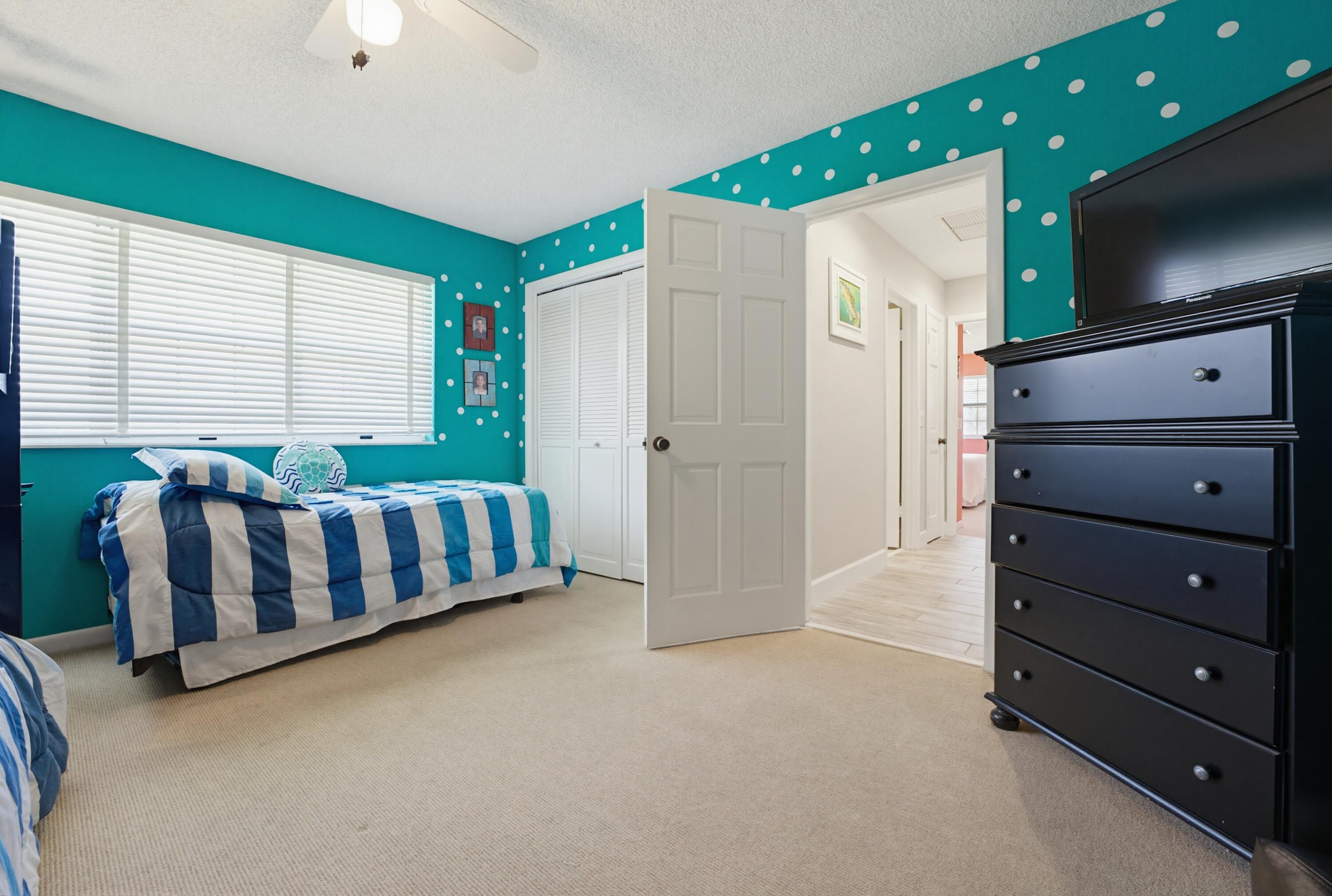 3491 Southeast Clubhouse Place Stuart, FL 34997 - Photo 34 of 43 a spacious bedroom with a bed and a television