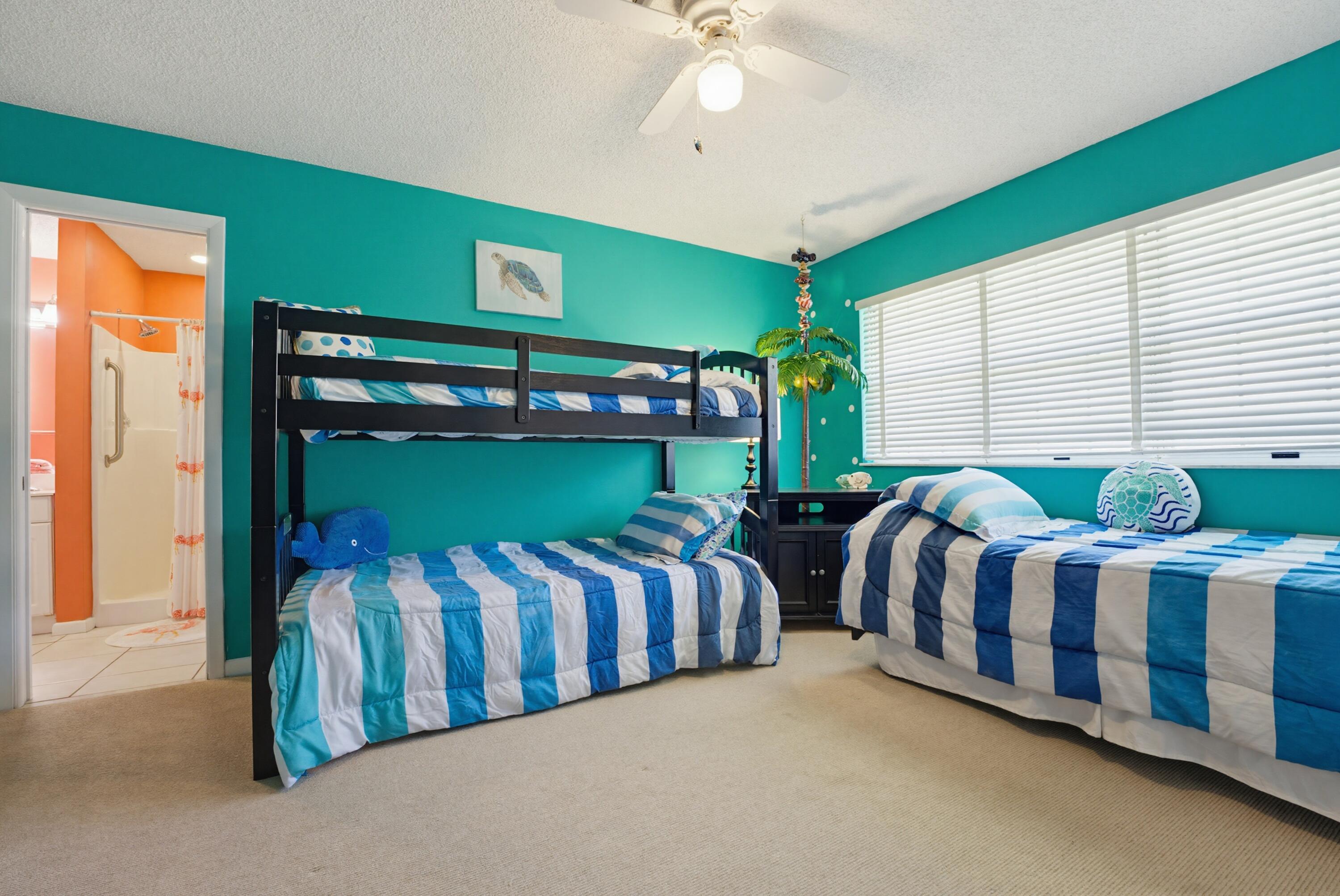 3491 Southeast Clubhouse Place Stuart, FL 34997 - Photo 35 of 43 a bedroom with three beds and a chandelier