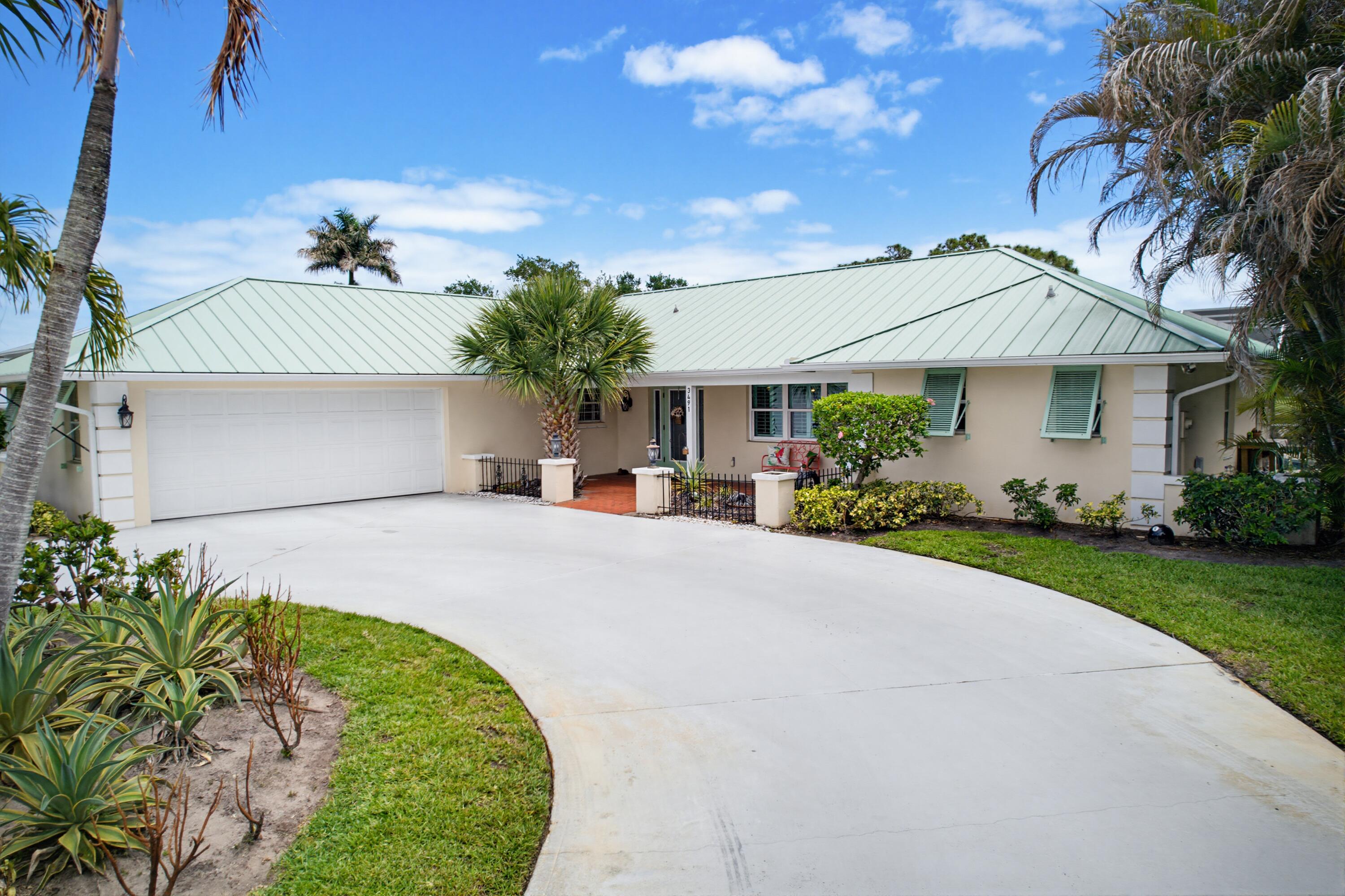 3491 Southeast Clubhouse Place Stuart, FL 34997 - Photo 40 of 43 a front view of a house with a garden