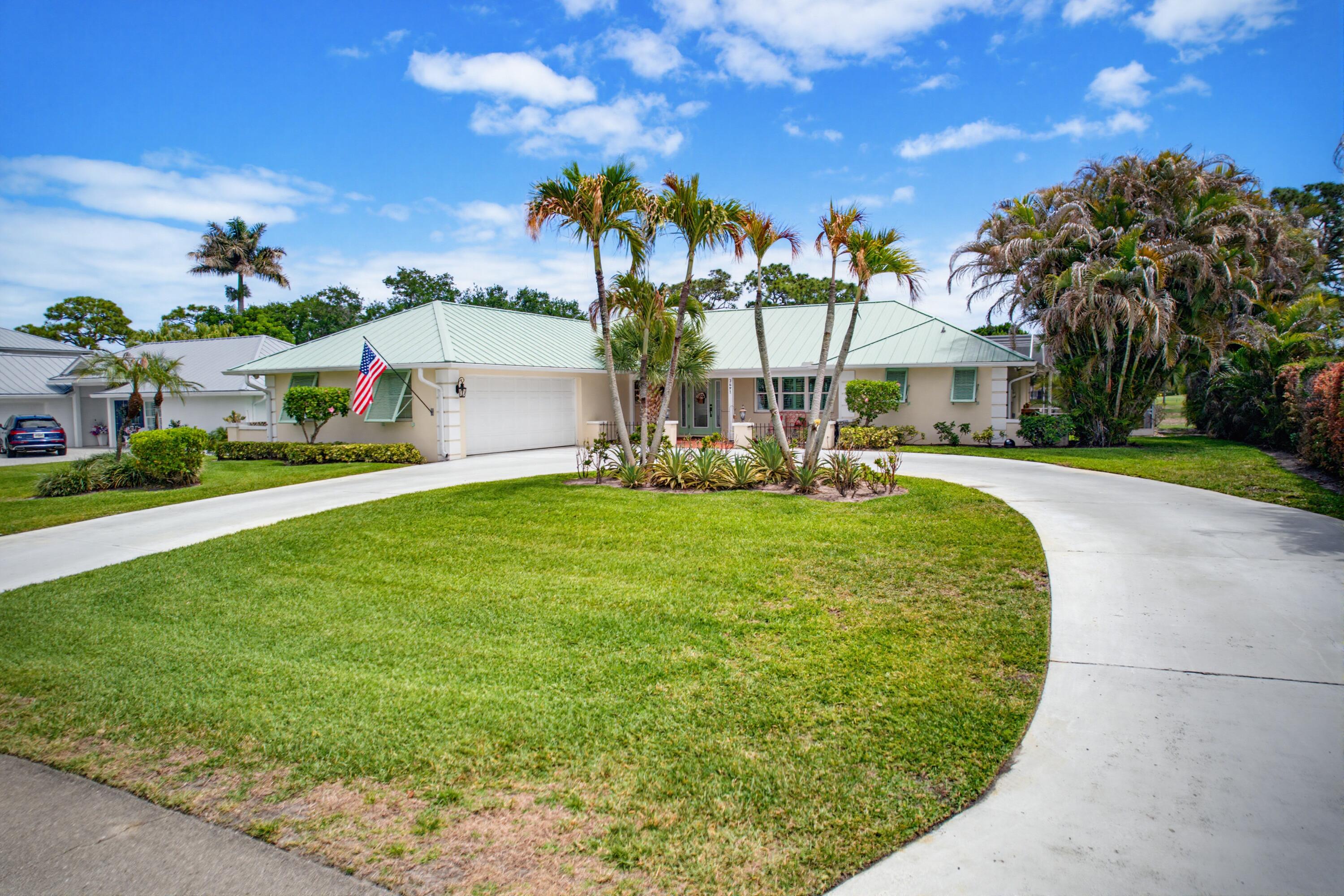 3491 Southeast Clubhouse Place Stuart, FL 34997 - Photo 41 of 43 a front view of a house with a yard and trees