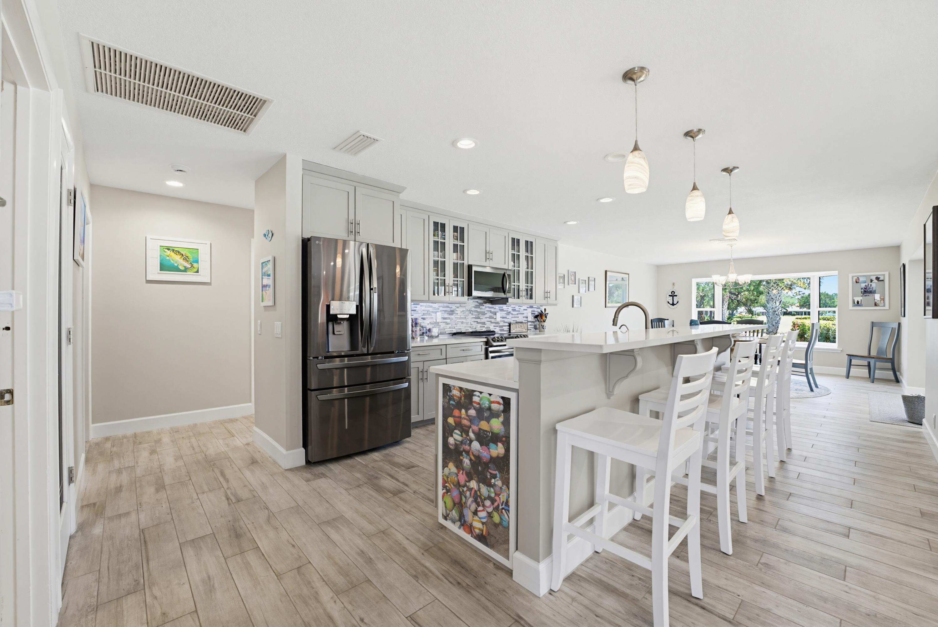 3491 Southeast Clubhouse Place Stuart, FL 34997 - Photo 5 of 43 a kitchen with stainless steel appliances kitchen island granite countertop a refrigerator and a stove top oven