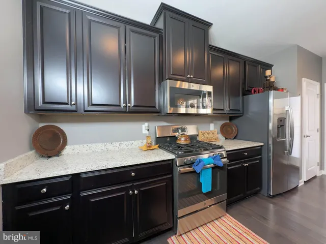 a kitchen with stainless steel appliances granite countertop a stove a refrigerator and a sink