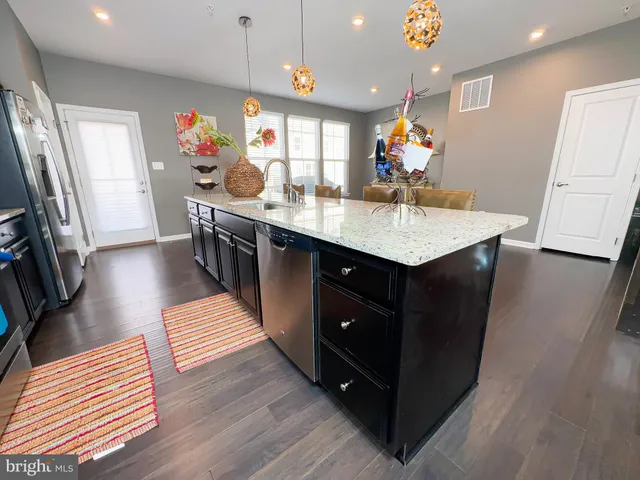 a kitchen with stainless steel appliances granite countertop a stove refrigerator and a sink