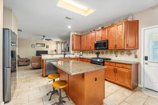 a kitchen with stainless steel appliances granite countertop a sink stove and cabinets