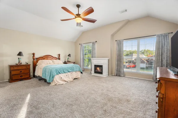 a spacious bedroom with a bed and a fireplace